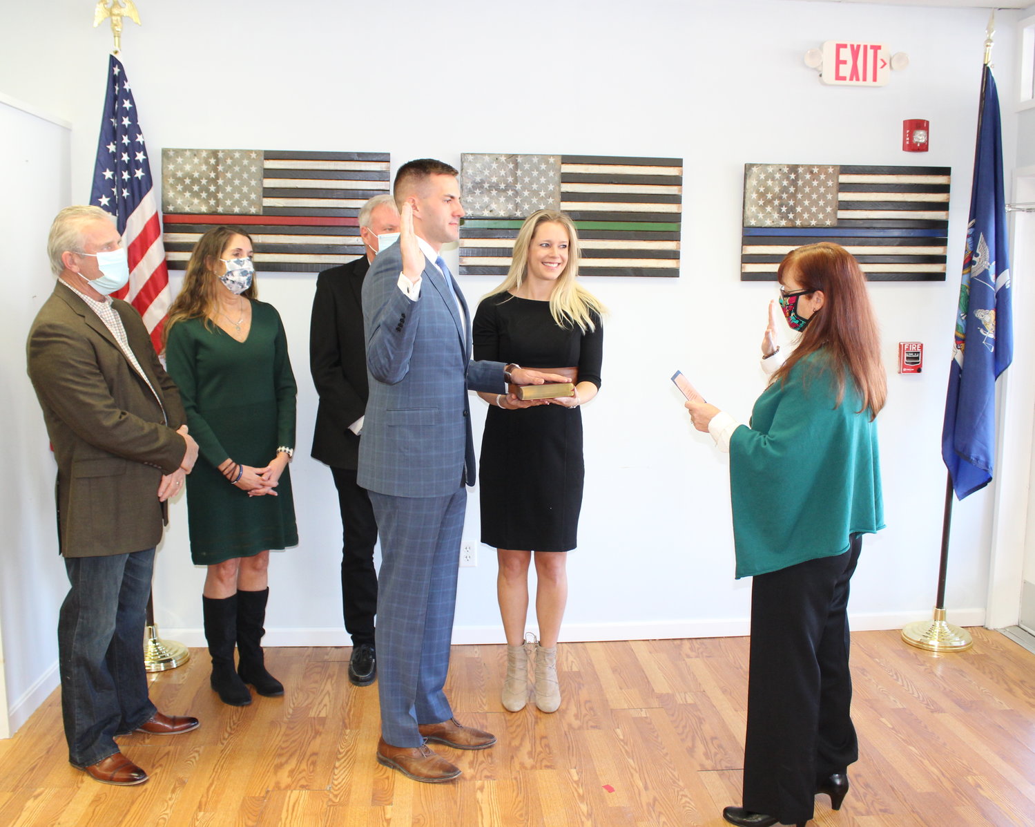 Assemblyman Colin Schmitt is administered the oath of Office by County Clerk Annie Rabbitt, Mrs. Nikki Schmitt holds the bible with family in the background. 