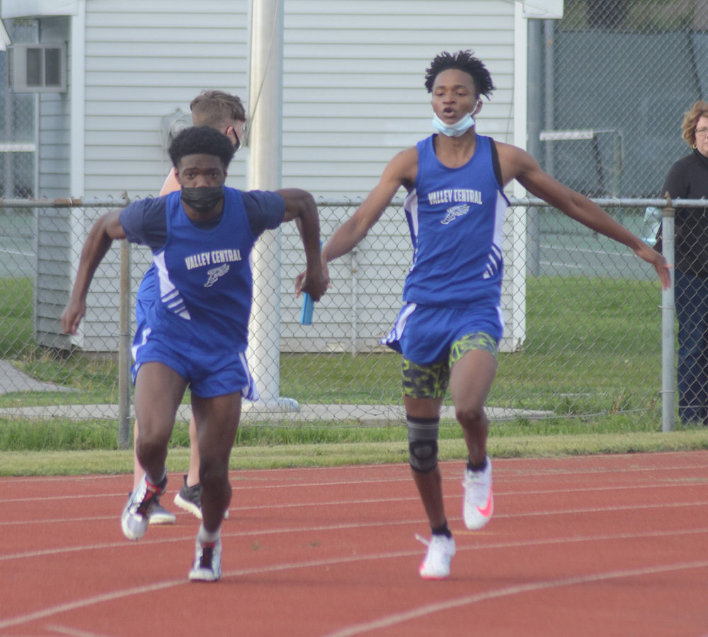 VC’s Valnick Exantus hands off to Derrick Gibson during the 4x100-meter relay.