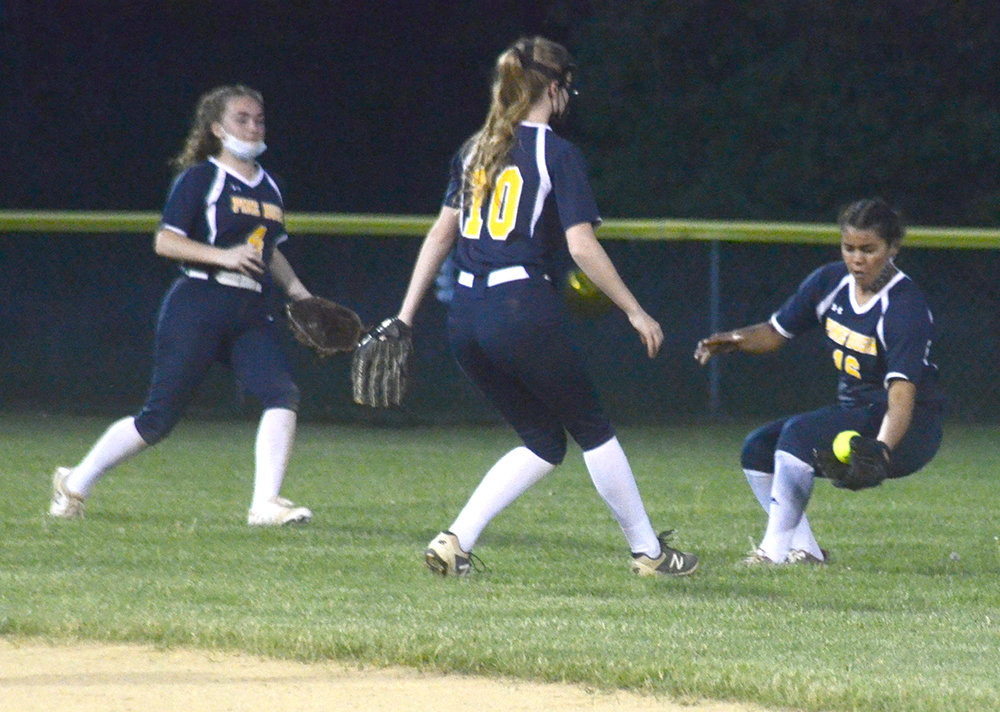 Pine Bush’s Kiara Vasquez (16) fields a base hit as shortstop Caitlyn Price (10) and left fielder Abigail Suleski converge during Wednesday’s OCIAA Division II game against the Washingtonville Wizards at Crawford Town Park in Pine Bush.