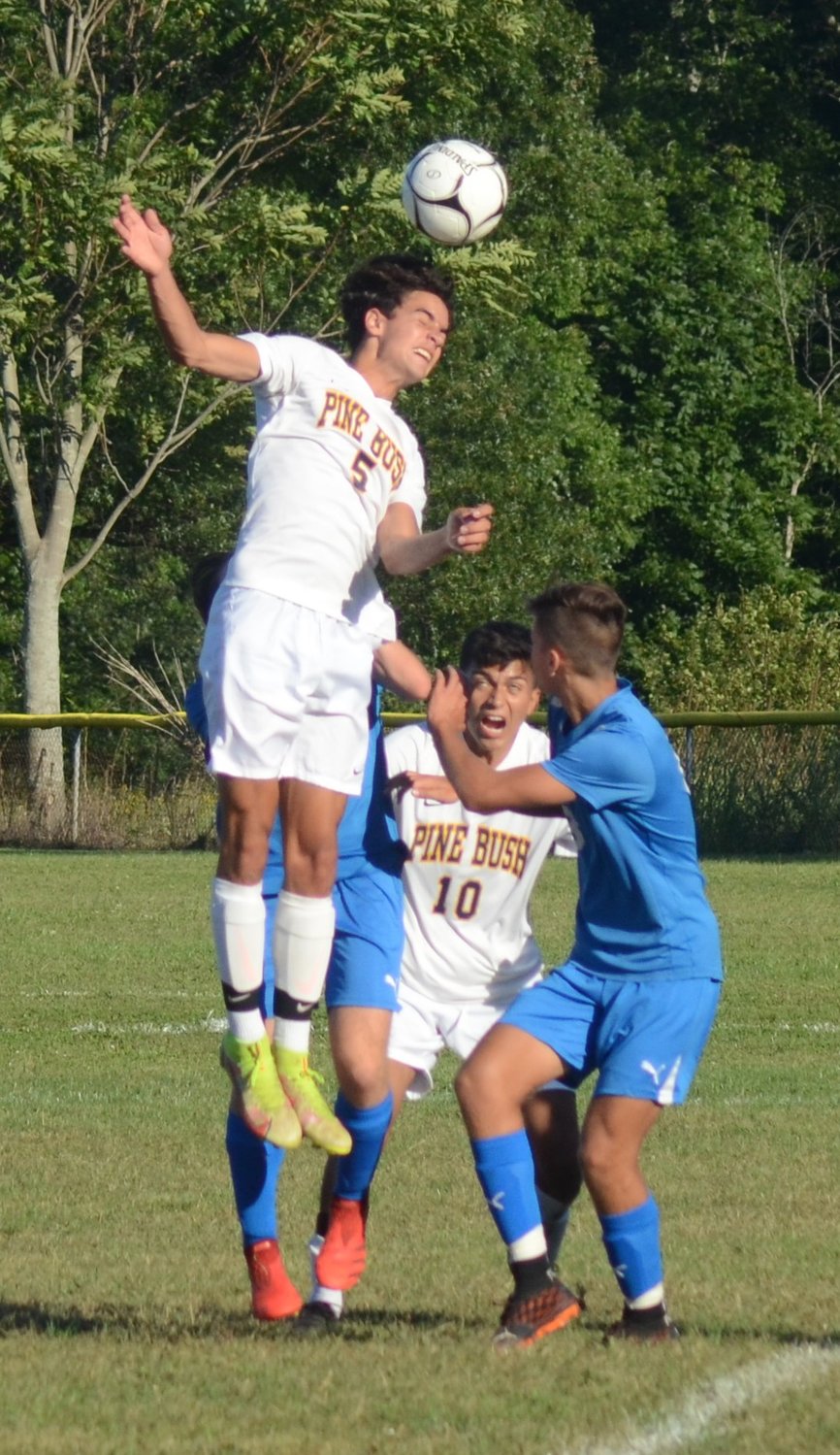 Pine Bush’s Joseph Darrell heads the ball toward the goal as teammate Sergio Gonzalez and Kyle Cocks Valley Central’s Connor Swart and looks on during Friday’s  game at Valley Central.