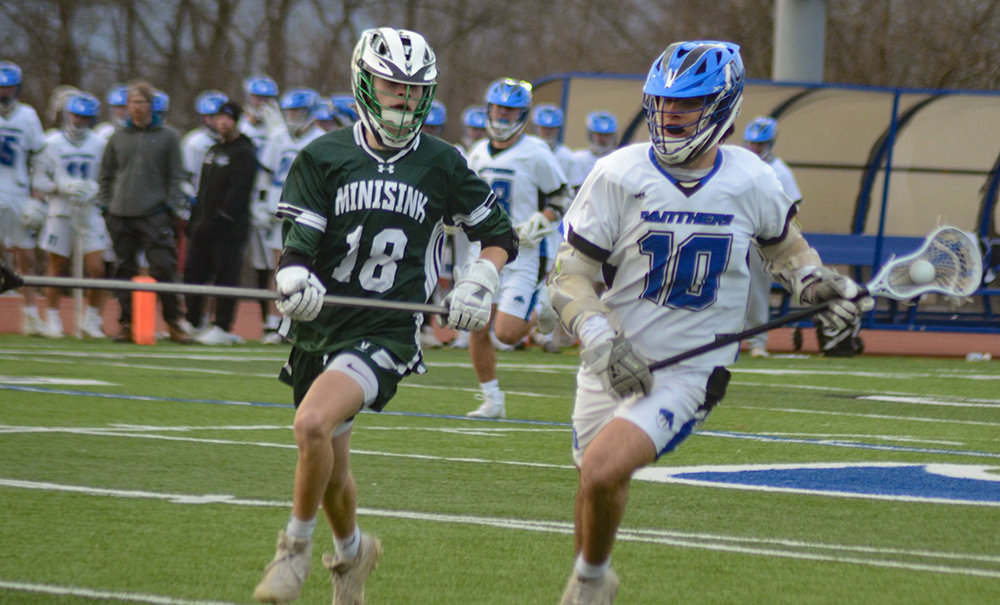 Wallkill’s Colin McCartney brings the ball down the field as Minisink Valley’s Gavin Fox defends during Wednesday’s non-league boys’ lacrosse game at Wallkill Senior High School.
