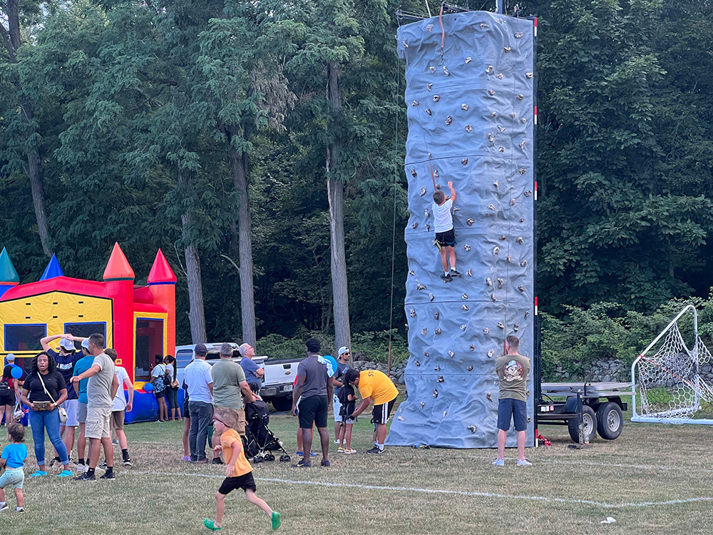 While some children enjoy the bouncy house, others brave the rock wall.