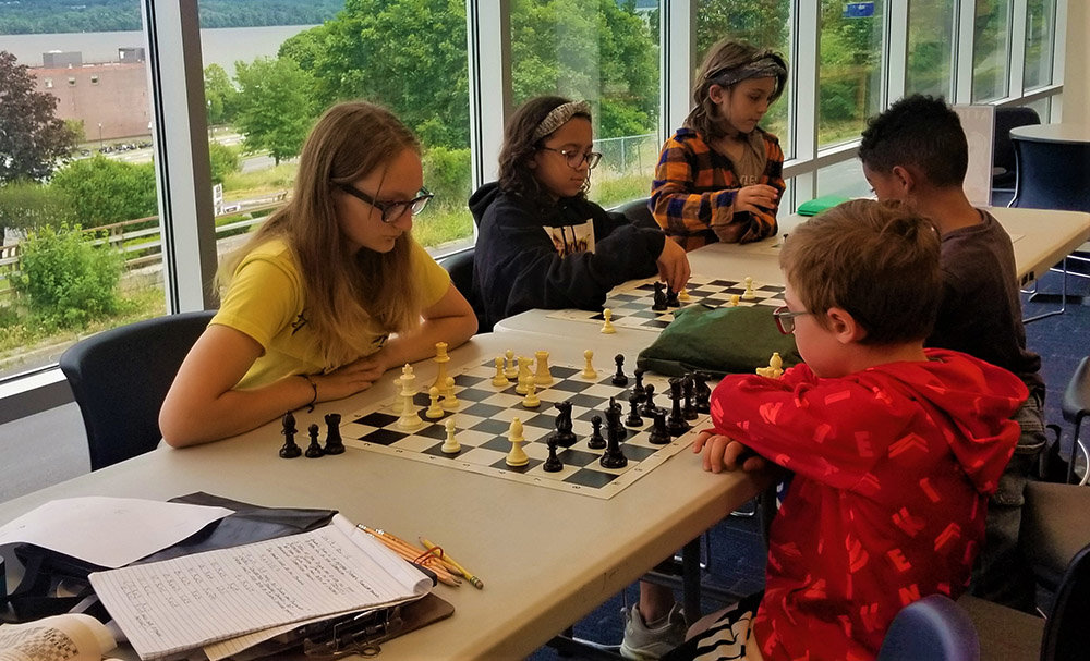 Several games of chess occur during the course of the community meeting with players at the beginner level to some with more experience.
