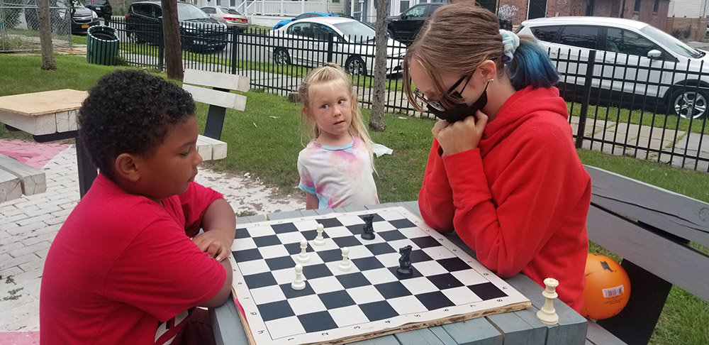 Jay Hayes [right] plays a game of chess with a fellow community member.
