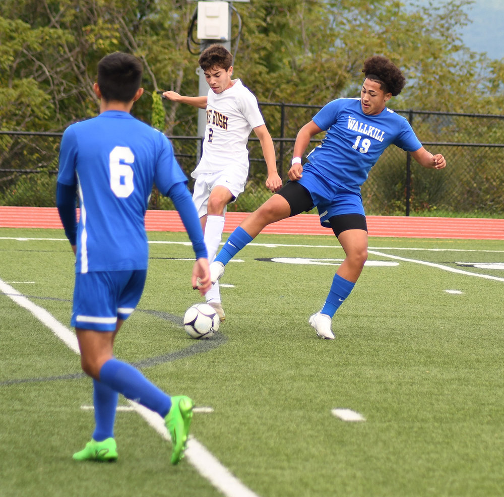 Wallkill’s Chris Banegas and Pine Bush’s Justin Martir battle for the ball as Wallkill’s Juan Ortega (6) looks on during Saturday’s non-league boys’ soccer game at Wallkill Senior High School.
