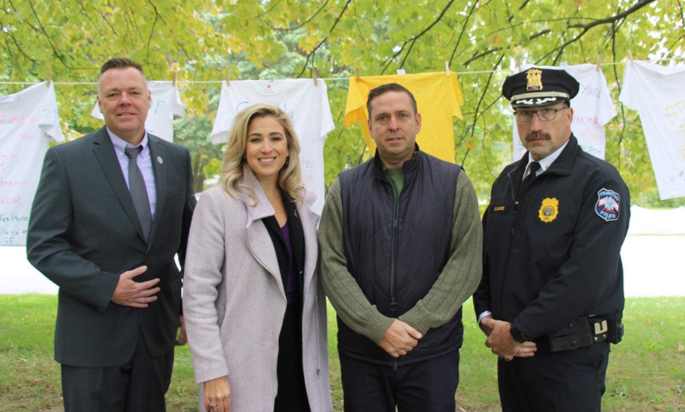 L - r: Port Jervis Police Chief William Worden, Kellyann Kostyal-Larrier, Executive Director of Fearless!, Orange County Executive Steven M. Neuhaus and Town of Crawford Police Chief Dominick Blasko in front of the Clothesline Project.