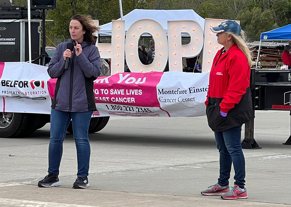 Eileen Connors [left] is welcomed as the guest speaker to speak to the crowd to begin the plane pull on her journey with cancer and encourages everyone to seek screening.