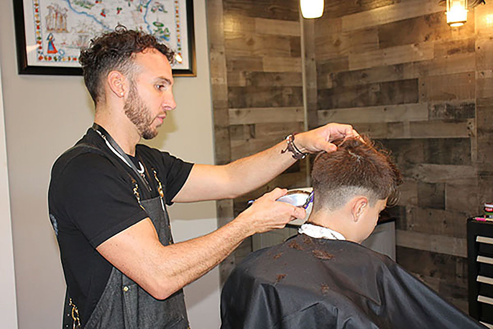 Chenzo Caci, a 2015 graduate of the former Barbering for New York State Licensing program at the Adult Career Education Center, and a 2005 graduate of the Ulster BOCES High School Equivalency program at the Career & Technical Center, opened up the doors to “Caci Barber Shop and Reptilium,” in October 2020. The business is a popular attraction where clients get 
both a great haircut and a gander at a collection of snakes and lizards housed in glass terraria.  Here, he does a trendy “fade” style on one of his clients