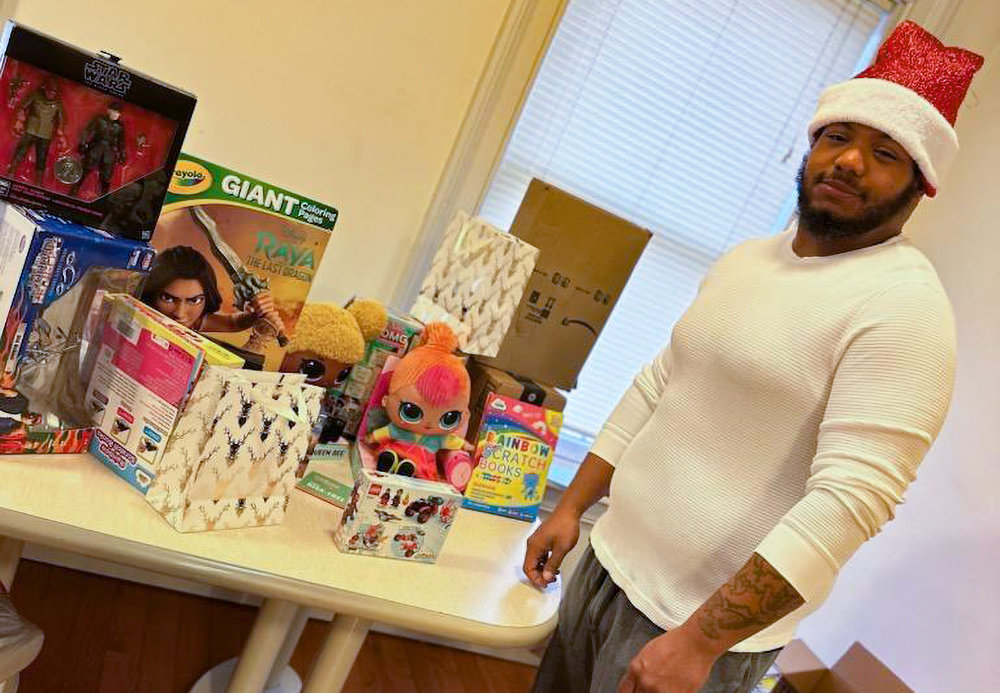 Harvel Brown stands with toys and other items currently being collected as part of his 3rd Annual Christmas Toy Drive.