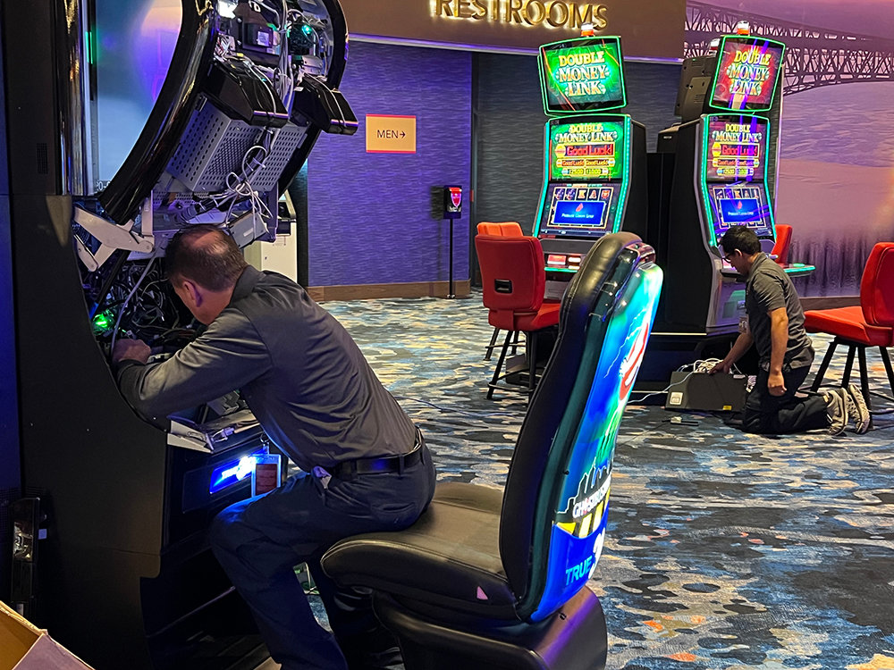 Technicians work on several gaming machines preparing for the grand opening.