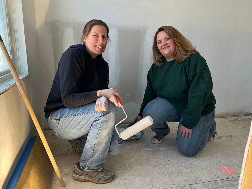 Volunteers Elise Beal (left) and Heidi Johnson help with the painting of the project at 142 North Miller.