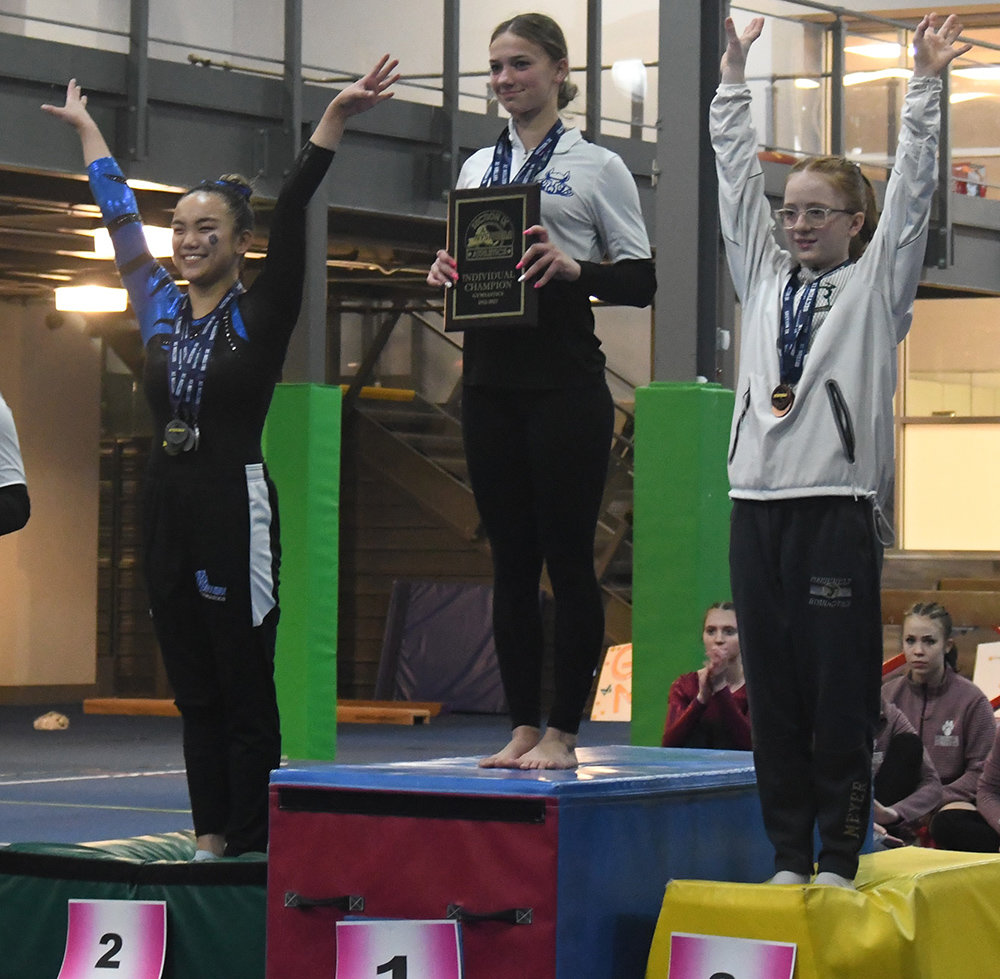 Valley Central's Reilly Benson holds the All-Around championship plaque after the Section 9 gymnastics championships on Feb. 13 at Epik Athletics in Middletown. Wallkill's Marlee McCullough, left, finished second and FDR's Julia Meyer is on the left.