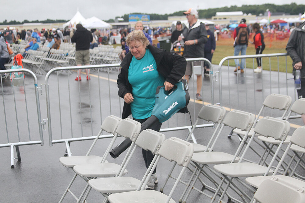 A volunteer found a novel way to dry off the chairs soaked by Saturday morning rain.