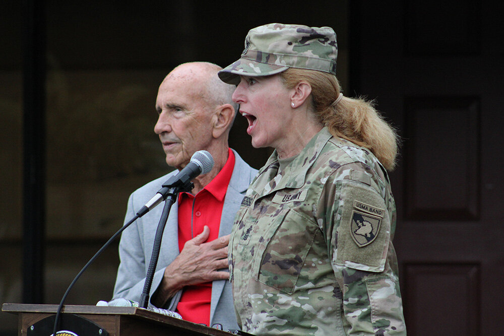 Sgt. Major MaryKay Messenger of the West Point Band performs a rendition of the National Anthem alongside Town Supervisor George Meyers.
