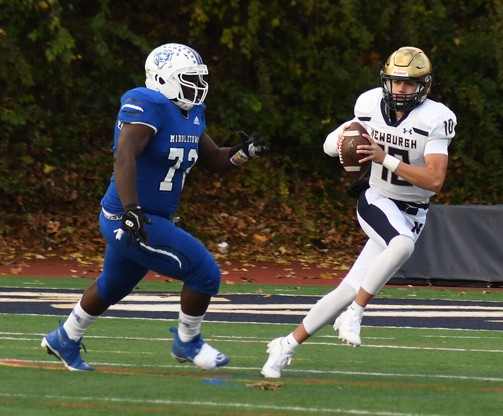 Newburgh quarterback Mason Hoover tries to get away from Middletown's Mekhi Wilson during Saturday's Section 9 Class AA championship football game at Academy Field in Newburgh.
