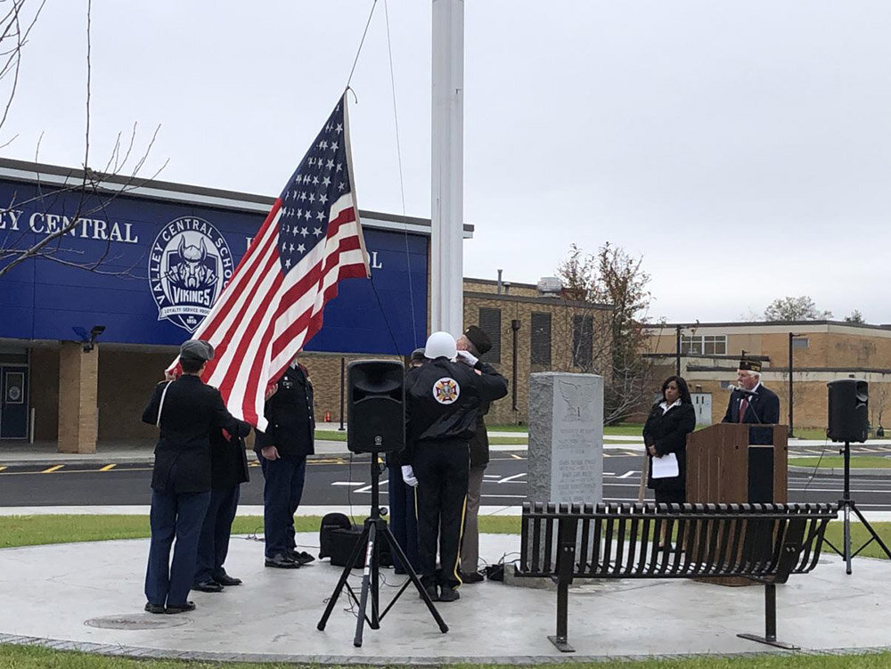 Members of Veterans of Foreign Wars hanging the Berger family’s flag